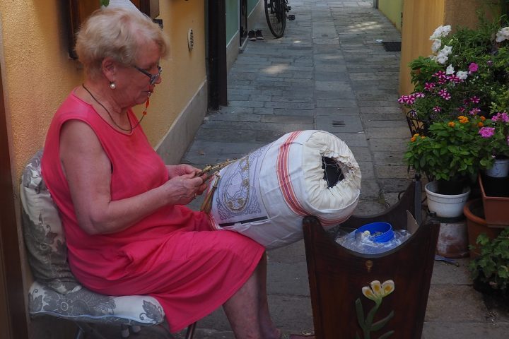 merlettaia lace maker using the old Pellestrina bobbin lace, no longer living there, and her padded cushion